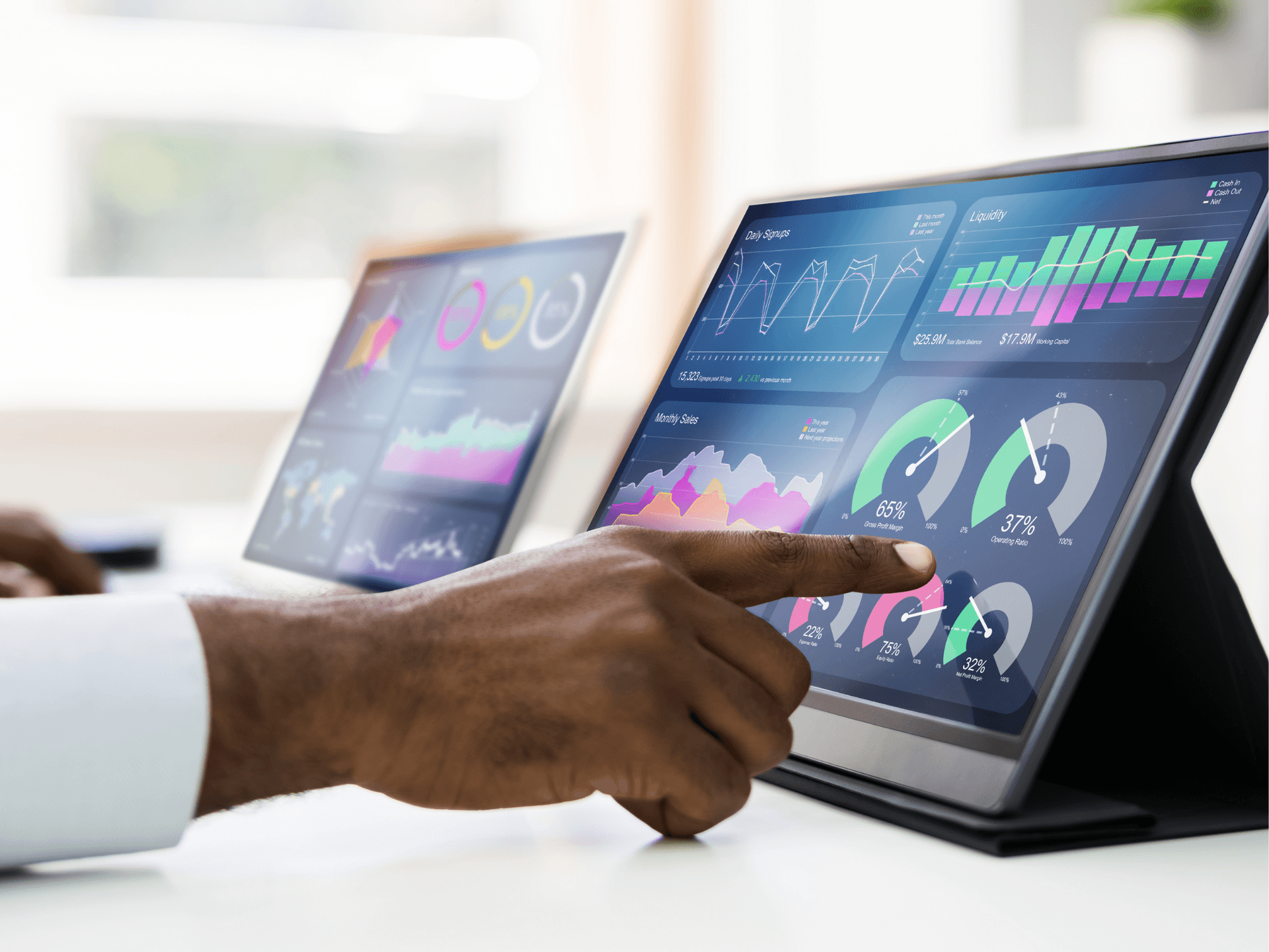 Person interacting with tablet displaying colorful data charts and graphs.